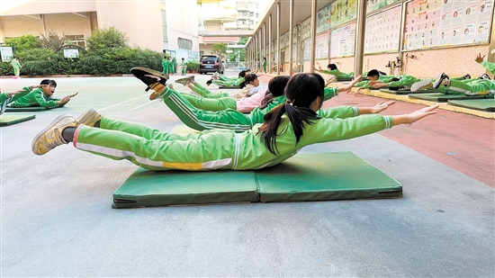 沙坪街道第三小學(xué)組建游泳隊，為學(xué)生打造提升游泳技能的平臺。圖為游泳隊學(xué)生正在進(jìn)行柔韌性和協(xié)調(diào)性訓(xùn)練。