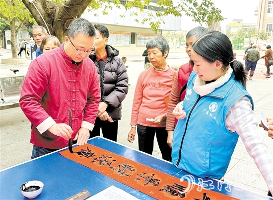 書法家手寫春聯(lián)，為群眾送祝福。